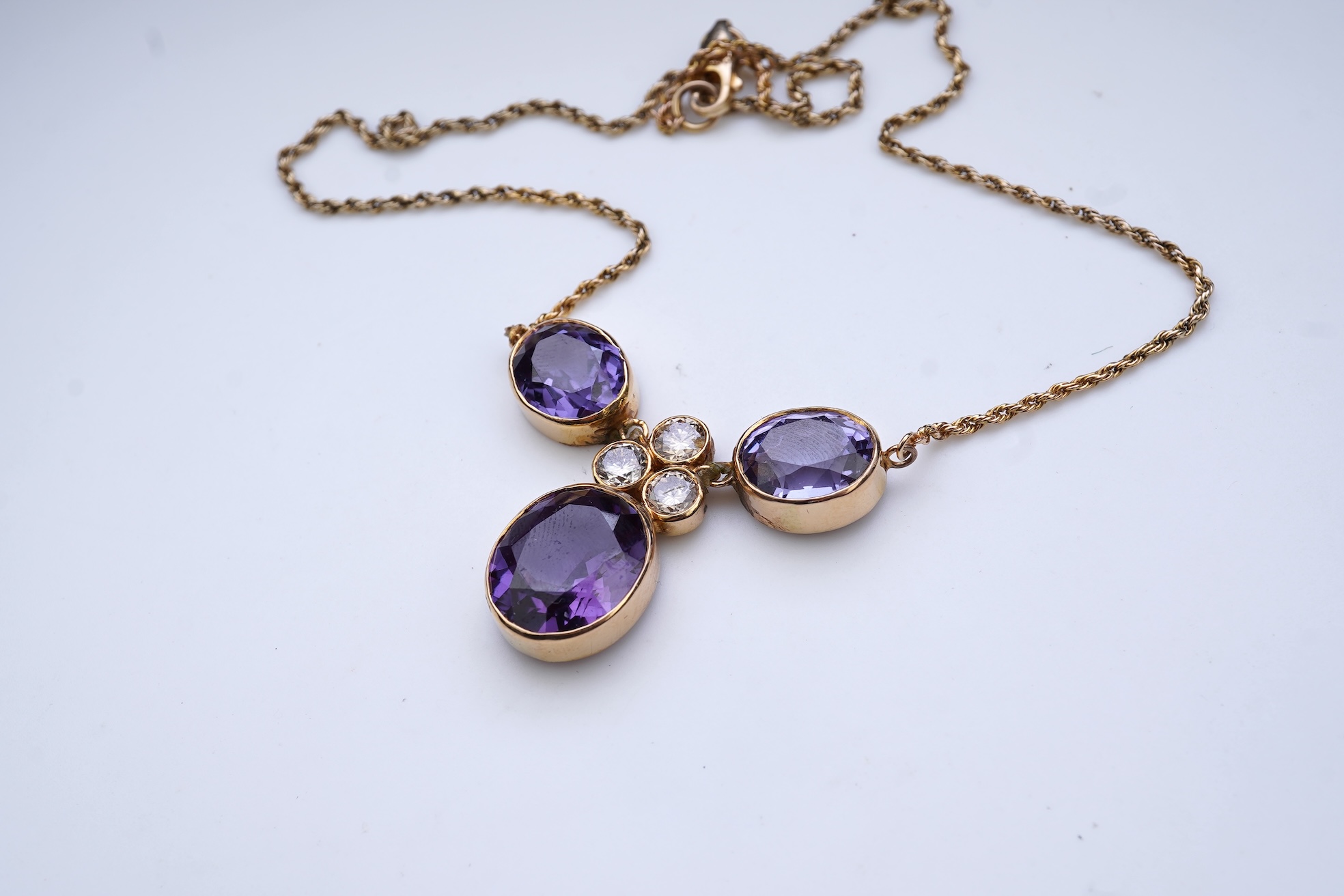 A synthetic colour-change sapphire and diamond pendant necklace